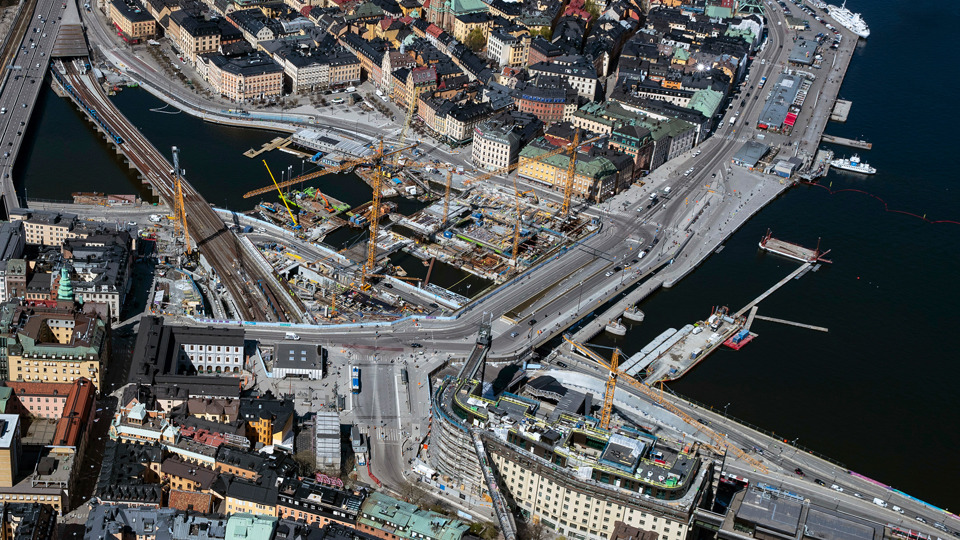 Flygfoto över Slussenområdet 2023. Vy från söder. Mellan Södermalm och Gamla stan pågår byggarbeten.
